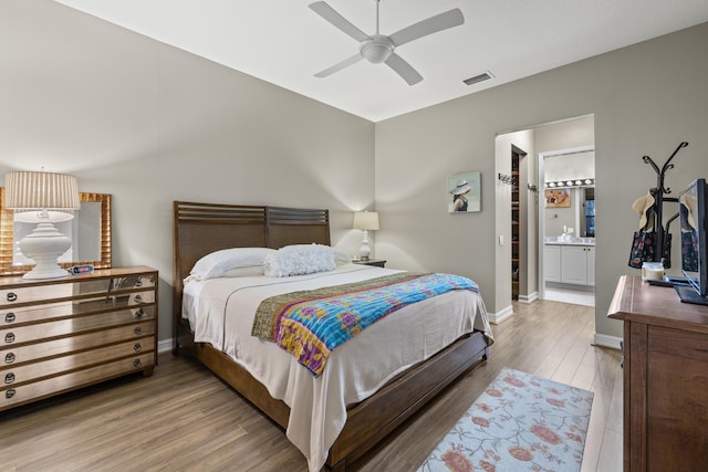 bedroom featuring hardwood / wood-style flooring, ensuite bath, and ceiling fan