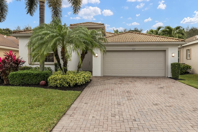 mediterranean / spanish house with a garage and a front lawn