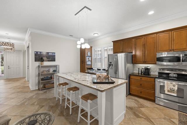 kitchen with a kitchen island, a breakfast bar, hanging light fixtures, stainless steel appliances, and light stone countertops