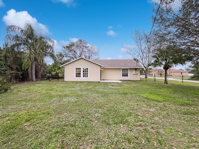 rear view of property featuring a lawn