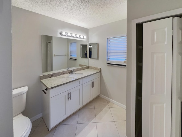 bathroom featuring vanity, toilet, tile patterned floors, and a textured ceiling