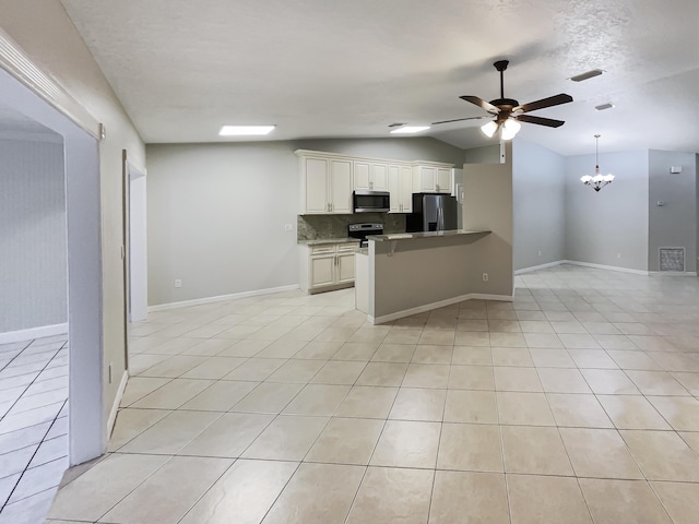 kitchen with light tile patterned floors, white cabinets, backsplash, stainless steel appliances, and ceiling fan with notable chandelier