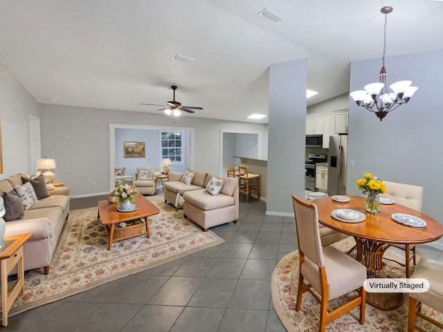 tiled living room with ceiling fan with notable chandelier and lofted ceiling