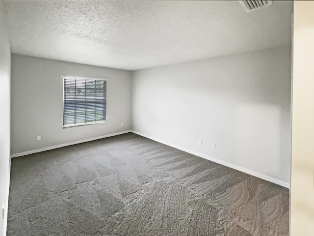 carpeted spare room with a textured ceiling