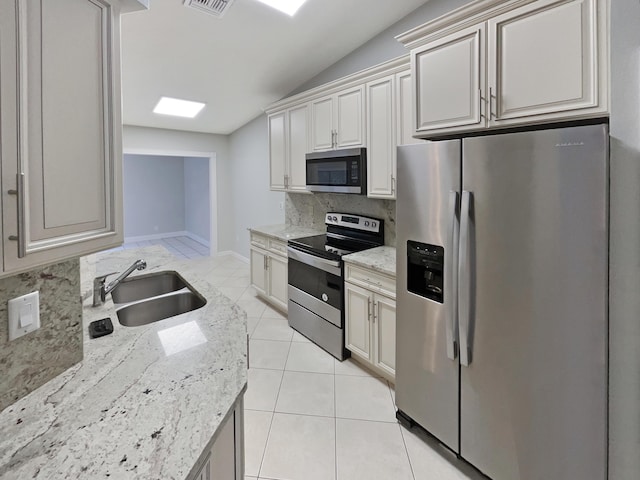 kitchen featuring light stone countertops, sink, appliances with stainless steel finishes, and tasteful backsplash