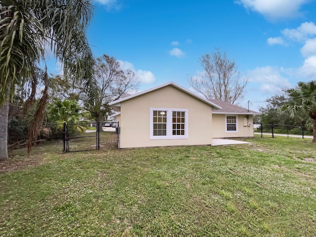 back of house with a yard and a patio