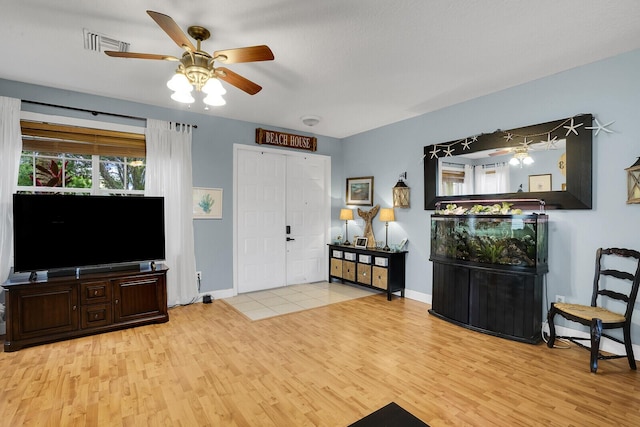 living room with ceiling fan and light hardwood / wood-style floors