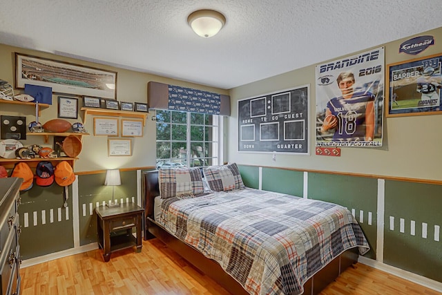 bedroom with light hardwood / wood-style floors and a textured ceiling