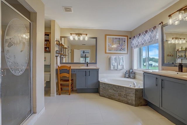 bathroom featuring vanity, tiled bath, and toilet