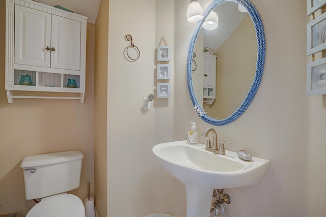 bathroom with vaulted ceiling, toilet, and sink