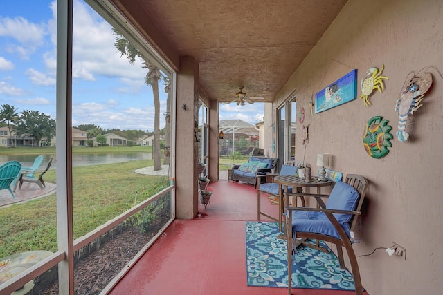 sunroom featuring a water view