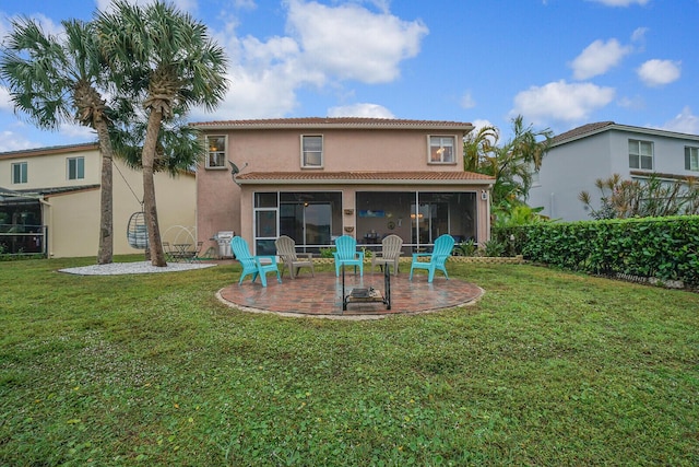 back of property featuring a lawn, a sunroom, and a patio