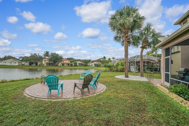 view of yard featuring a lanai, a patio area, and a water view