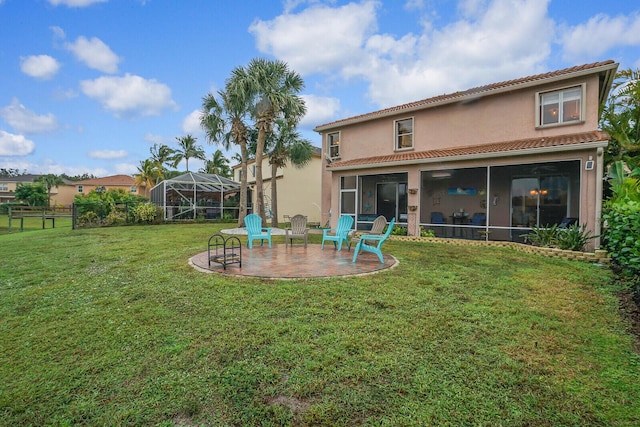 rear view of house featuring a patio, a lanai, and a yard