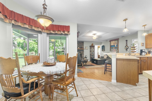 dining space with a fireplace and light tile patterned flooring