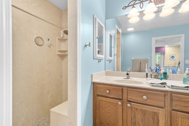 bathroom featuring vanity, a chandelier, and a shower