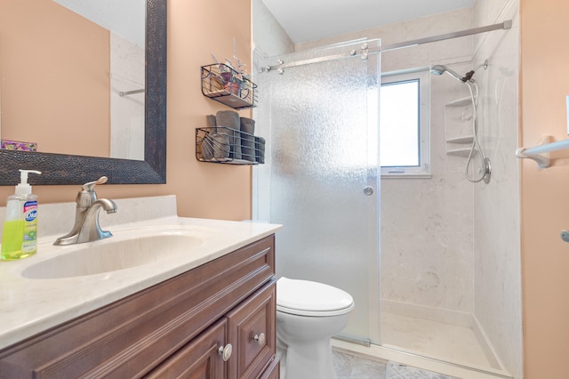 bathroom with vanity, toilet, and a shower with door