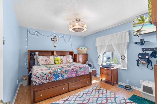 bedroom featuring hardwood / wood-style floors and a textured ceiling