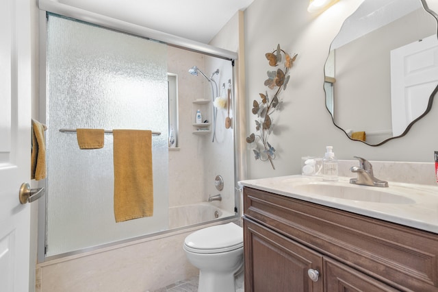 full bathroom featuring combined bath / shower with glass door, toilet, and vanity