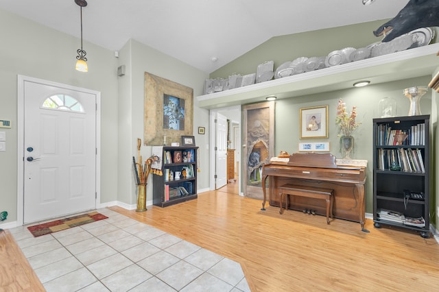 entryway featuring light tile patterned floors and lofted ceiling