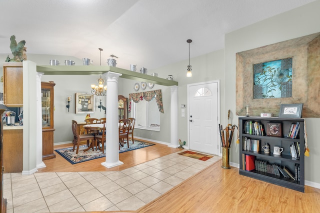 entryway featuring light tile patterned floors, lofted ceiling, and a notable chandelier