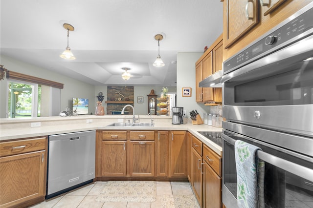 kitchen with sink, decorative light fixtures, a raised ceiling, and stainless steel appliances