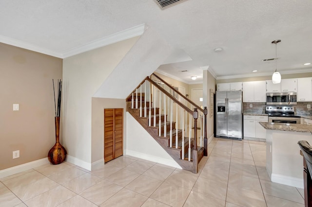 kitchen featuring white cabinetry, stainless steel appliances, ornamental molding, stone countertops, and decorative backsplash