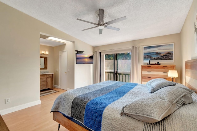 bedroom with vaulted ceiling, access to exterior, a textured ceiling, and light hardwood / wood-style flooring