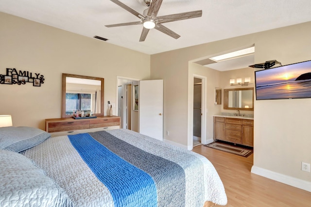 bedroom with sink, connected bathroom, ceiling fan, and light hardwood / wood-style flooring