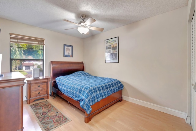 bedroom featuring hardwood / wood-style flooring, ceiling fan, and a textured ceiling