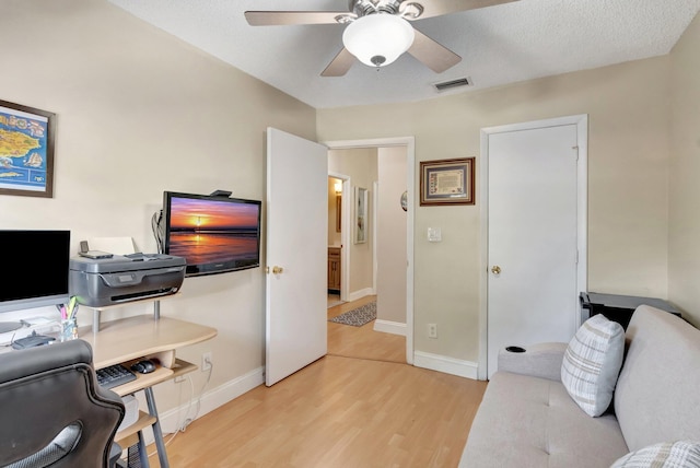 office area featuring ceiling fan, a textured ceiling, and light wood-type flooring