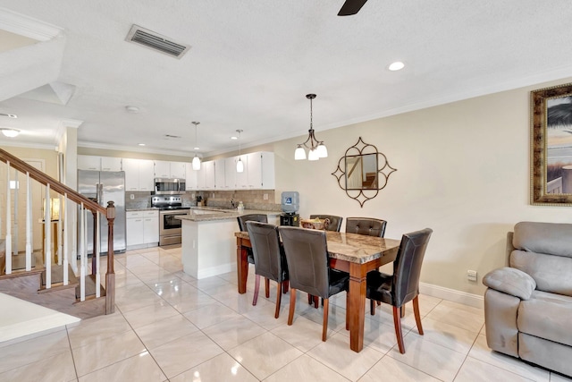 tiled dining area with an inviting chandelier and ornamental molding