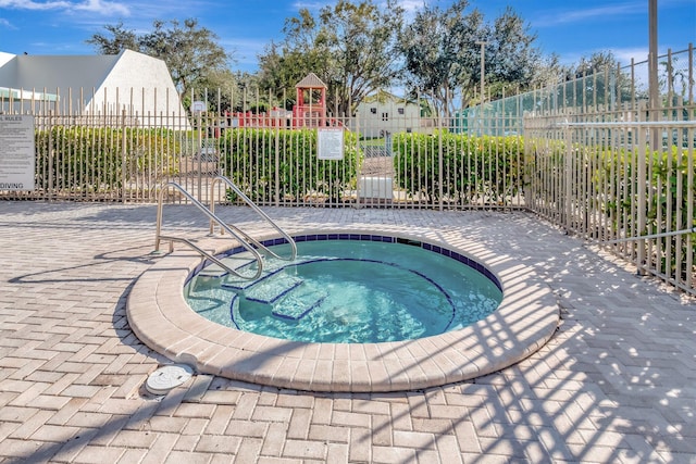 view of swimming pool with a hot tub and a playground