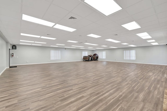 unfurnished room featuring a drop ceiling and light wood-type flooring