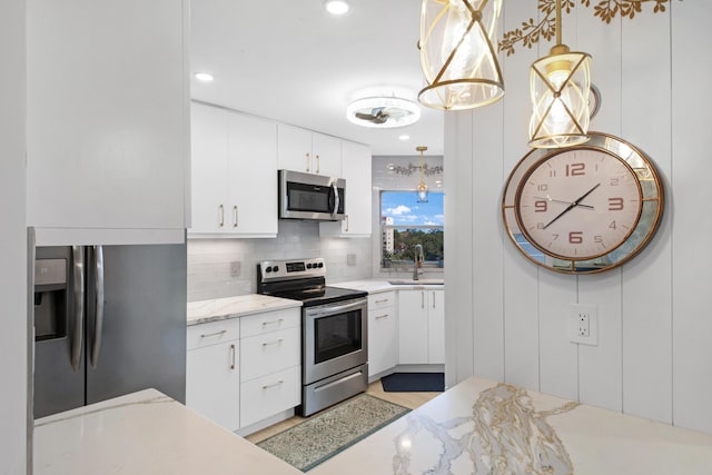 kitchen with white cabinets, stainless steel appliances, backsplash, and sink