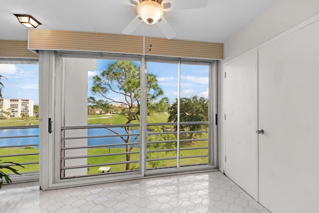 doorway featuring ceiling fan and a water view