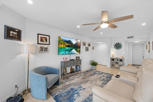 living room with ceiling fan, ornamental molding, and light hardwood / wood-style floors