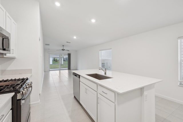 kitchen with white cabinetry, appliances with stainless steel finishes, sink, and a kitchen island with sink