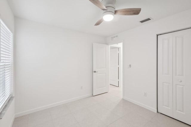 unfurnished bedroom featuring ceiling fan and a closet