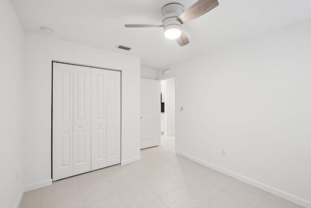 unfurnished bedroom with ceiling fan and a closet