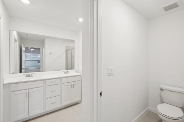 bathroom featuring vanity, tile patterned floors, and toilet