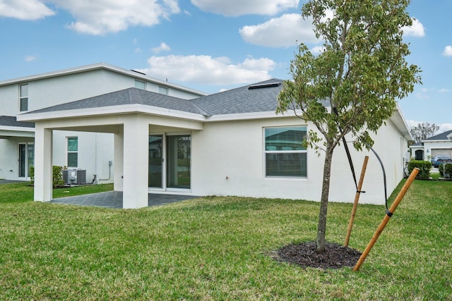 rear view of property featuring a yard, a patio area, and central air condition unit