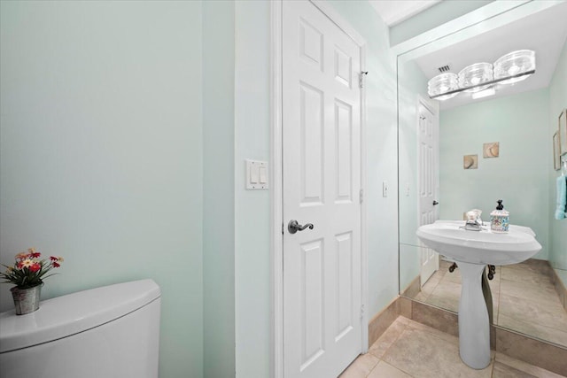 bathroom with toilet and tile patterned floors