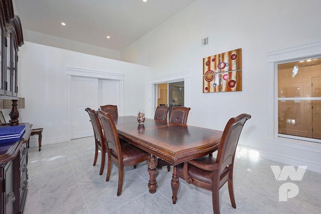 dining area featuring a towering ceiling