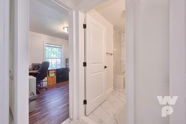 bathroom featuring a textured ceiling and walk in shower