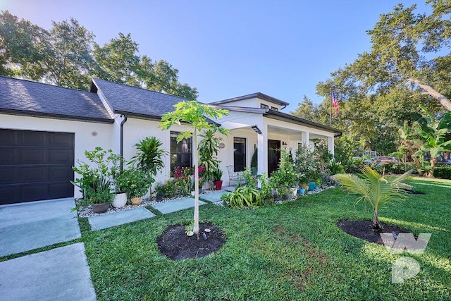 view of front facade featuring a porch, a garage, and a front lawn