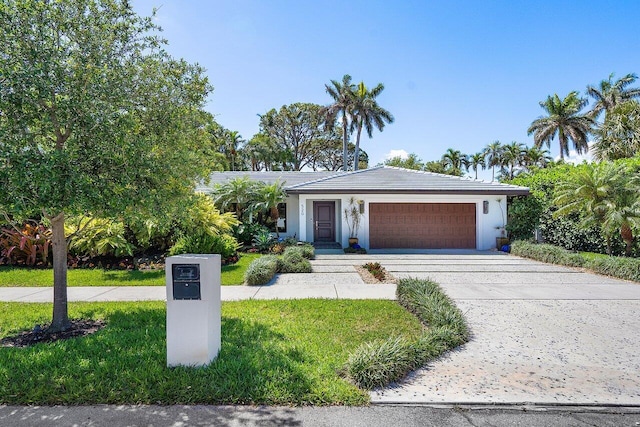 view of front of home with a front yard and a garage