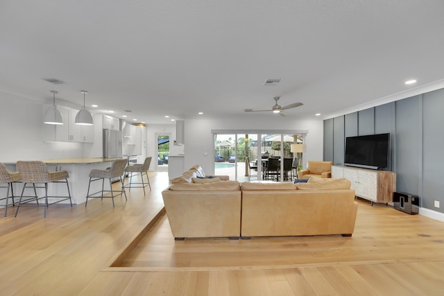 living room with ceiling fan and light wood-type flooring