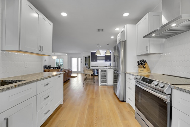 kitchen with stainless steel appliances, white cabinets, beverage cooler, and wall chimney exhaust hood