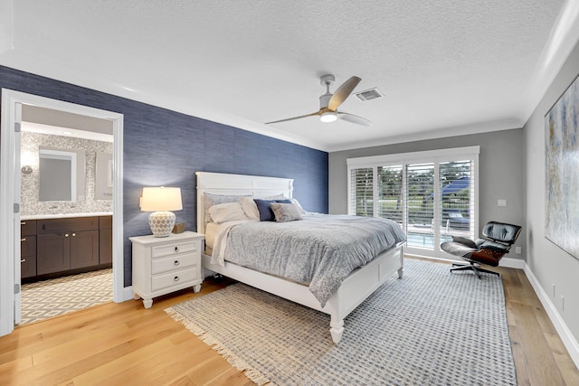 bedroom with connected bathroom, access to exterior, ceiling fan, light hardwood / wood-style floors, and crown molding